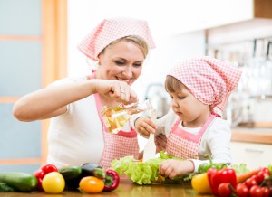 Мама с дочкой на готовят еду на кухне - фото