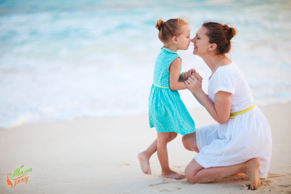 Mother and daughter enjoying time на tropical beach